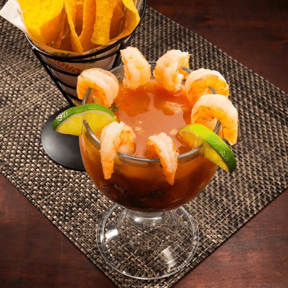 El Vaquero's shrimp cocktail with lime wedges and a side of tortilla chips.