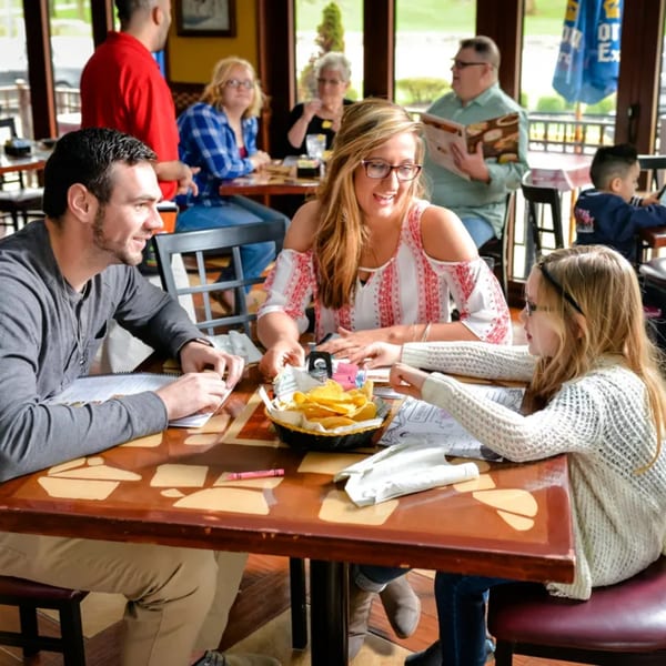 A family enjoying chips and salsa at a table in El Vaquero Mexican restaurant.